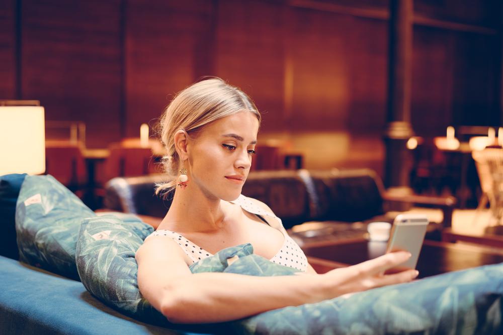 woman looking at her phone in a hotel lobby